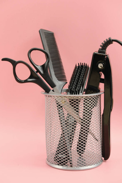 Haarstylisten-Werkzeuge in einem Korb. Schere, Bürste, Kamm. Lockenstab,  - Foto, Bild