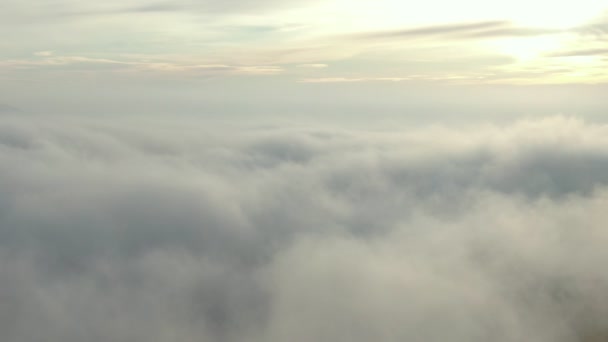 Kamera liikkuu hitaasti paksujen pilvien yli horisonttiin nousevan auringon kanssa. Lennokki taivaalla. 4 k. - Materiaali, video