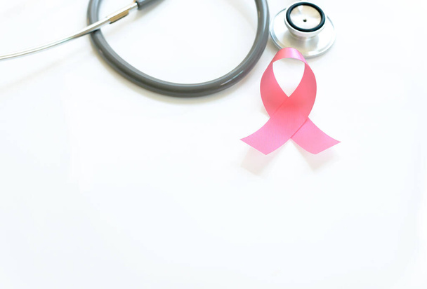 Pink ribbon and stethoscope on white background, closeup. Breast cancer awareness concept - Фото, зображення