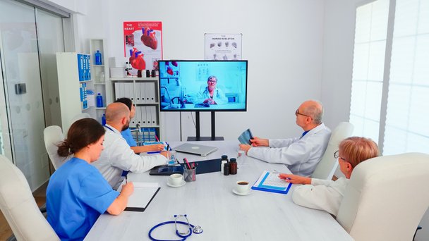 Gruppo di medici che discutono con un medico esperto durante la videoconferenza - Foto, immagini