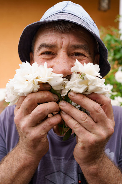 Gülümseyen adam beyaz güller - Fotoğraf, Görsel