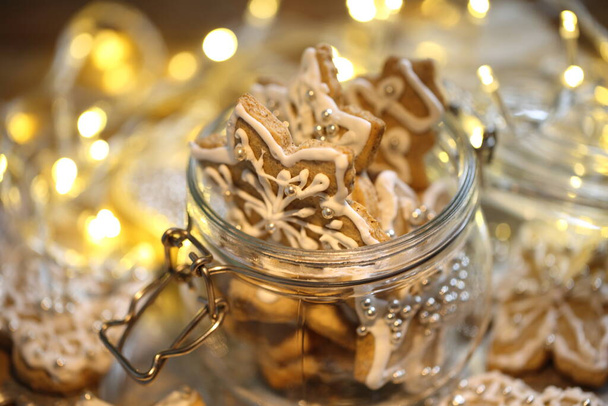 Glazed gingerbread cookies on the background of a burning garland - Foto, Imagen