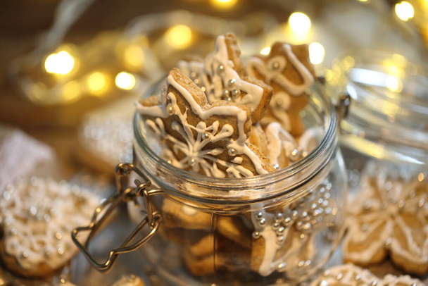 Glazed gingerbread cookies on the background of a burning garland - Foto, Imagem