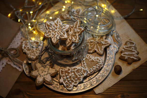 Glazed gingerbread cookies on the background of a burning garland - 写真・画像