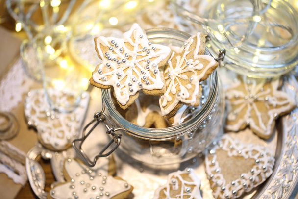 Glazed gingerbread cookies on the background of a burning garland - Фото, изображение