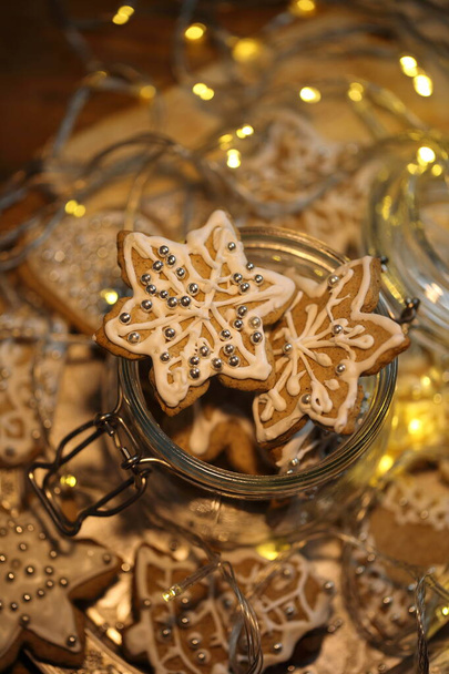 Glazed gingerbread cookies on the background of a burning garland - Fotoğraf, Görsel
