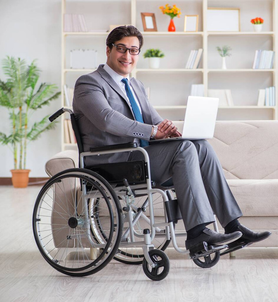 Uomo d'affari disabile sulla sedia a rotelle che lavora a casa - Foto, immagini