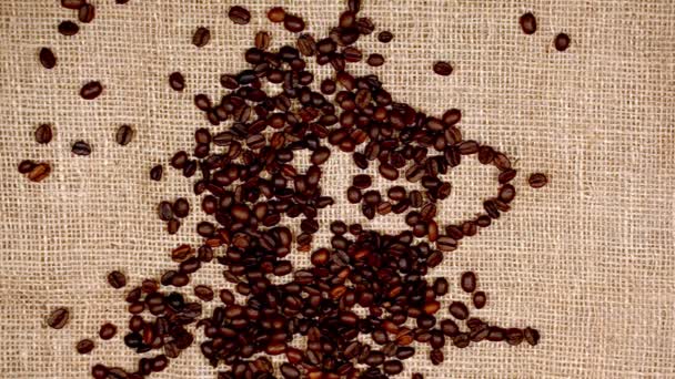 Roasted coffee beans arranged in the form of coffee cup logo. - Footage, Video