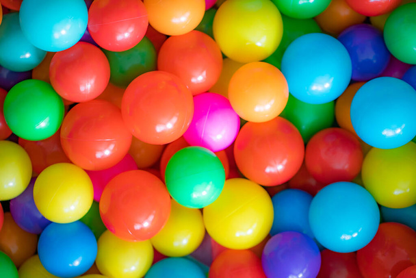 Colorful child balls. Multi-colored plastic balls. Achildren's playroom. Background texture of multi-colored plastic balls on playground - Photo, Image