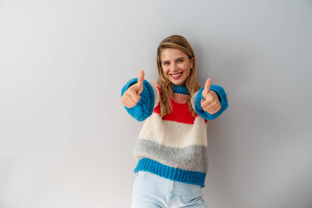 Cheerful casual woman standing isolated on white background, showing thumbs up - Zdjęcie, obraz