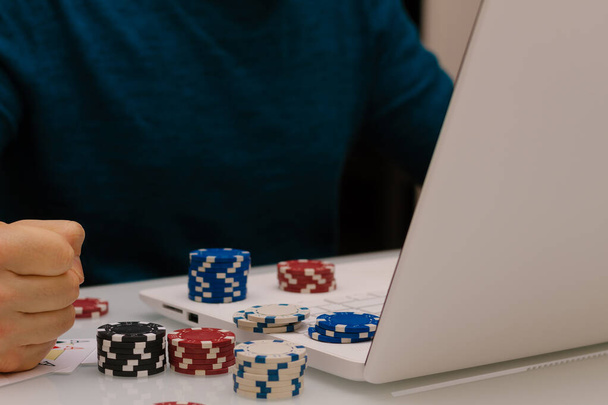 Genç adam kumar sitelerinde bilgisayarıyla oynuyor. Online kumarhane poker ruleti. Yaşam tarzı. Kazanan ya da iflas eden milyoner olur.. - Fotoğraf, Görsel