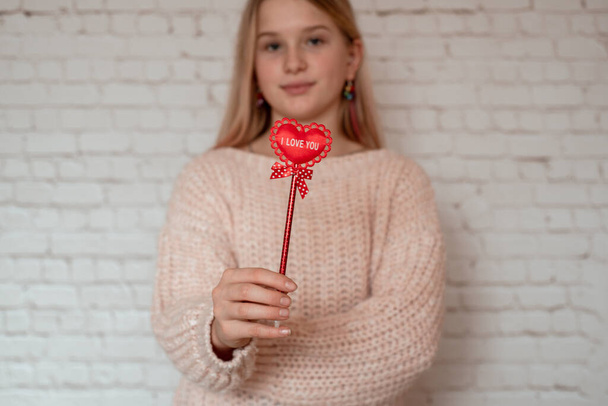 bonito sorrindo menina segurando vermelho tecido coração com eu amo você assinar no pau - Foto, Imagem