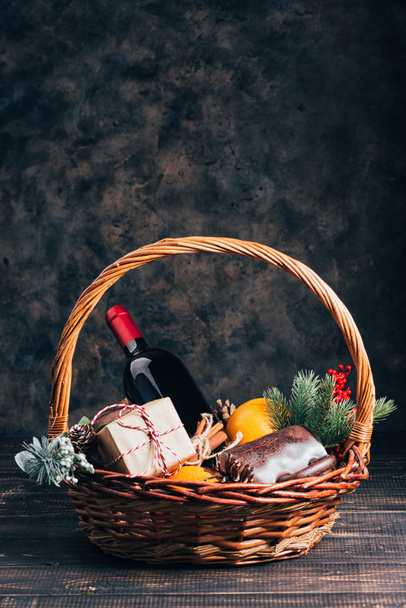 Бутылка красного вина в корзине рождественских подарков. - Фото, изображение