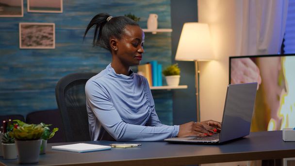 Fekete nő gépel a számítógépen, és ír a bot jegyzetek - Fotó, kép