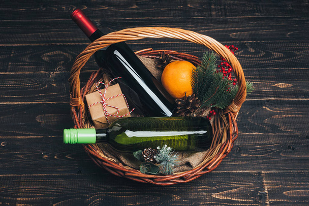 Bottles of red and white wine in Christmas gift basket - Photo, image