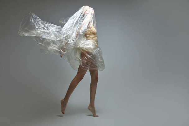 side view on female in a plastic bag, breaking free from plastic trash - Foto, Imagen