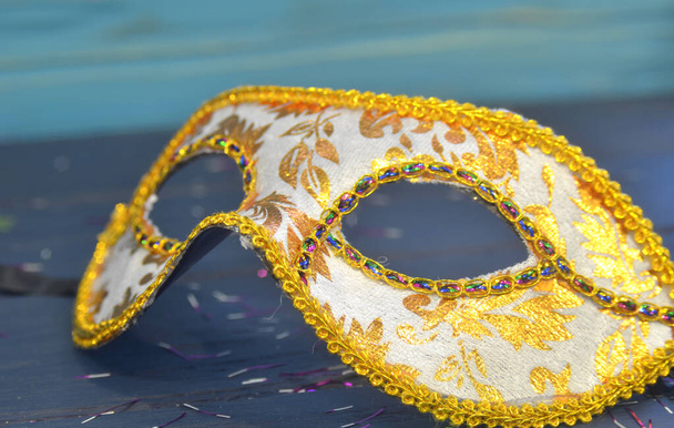 Mardi gras Maske und Perlen auf einem hölzernen Hintergrund. Madi Gras Karnevalszubehör, Konfetti, Festliche, Venezianische oder Karnevalsmaske. Konzept Maskerade-Feier - Foto, Bild