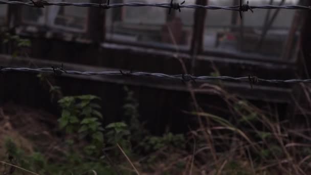 暗い空の中傾斜ショットに対する農民のフィールド内の有刺鉄線フェンス - 映像、動画