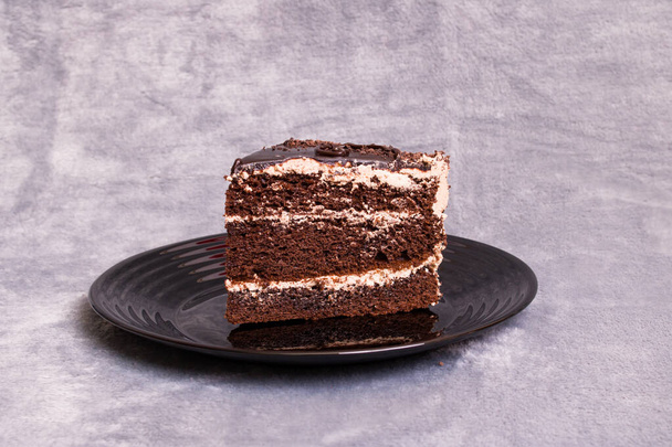 Pezzo di torta al cioccolato su uno sfondo grigio, copia lo spazio - Foto, immagini
