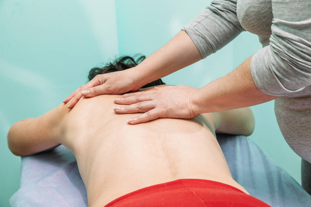 physiotherapist doing back massage to her patient in medical office - Photo, Image