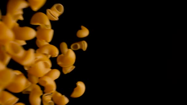 Italské těstoviny potrubí rigate pádu shora dolů do černého pozadí ve zpomaleném filmu - Záběry, video