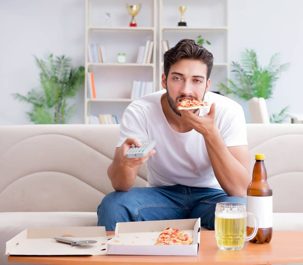 Man eating pizza having a takeaway at home relaxing resting - Foto, Imagen