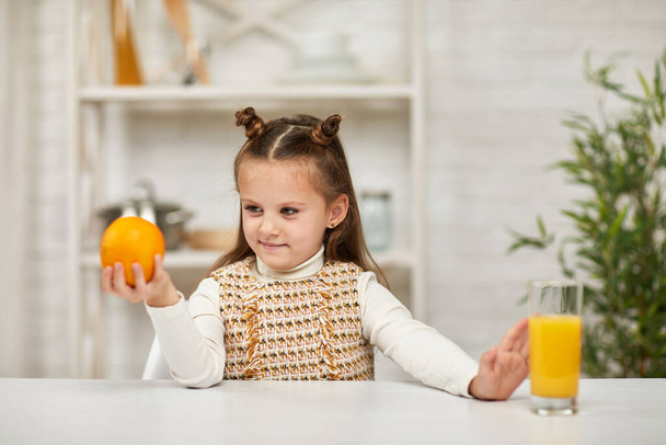 little child girl holding oranges and juice - Foto, Imagen