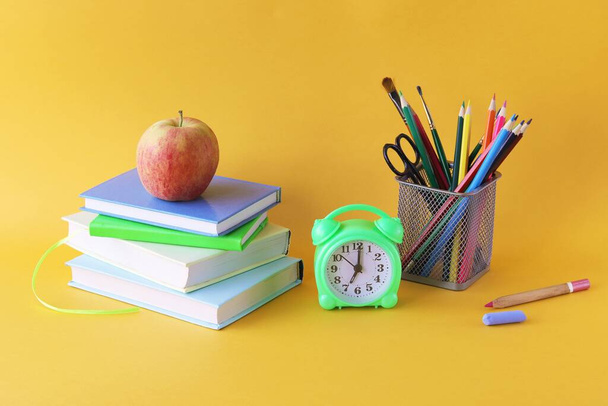 Papelería escolar, despertador en el escritorio, concepto de aprendizaje en el hogar, de vuelta a la escuela  - Foto, Imagen