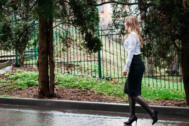 Young business woman in skirt walking outdoors - Fotoğraf, Görsel