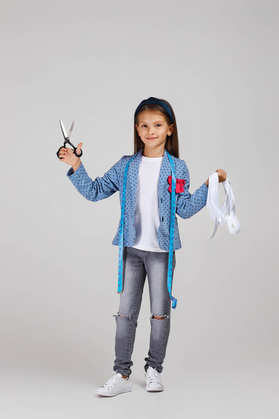 happy little girl holding tape measure and scissors - Фото, зображення