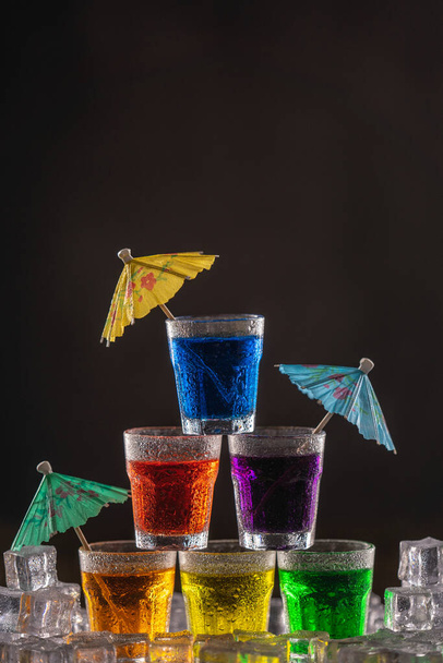 Pyramide de tirs à l'alcool coloré, décorée de parapluies pour cocktails - Photo, image