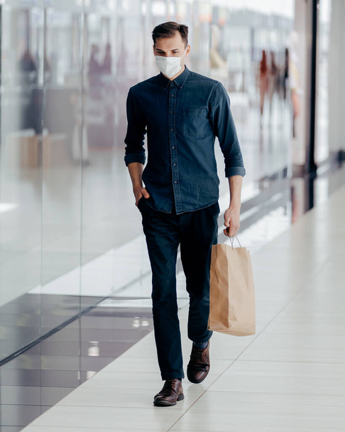man in a protective mask passing near a supermarket. - Fotografie, Obrázek