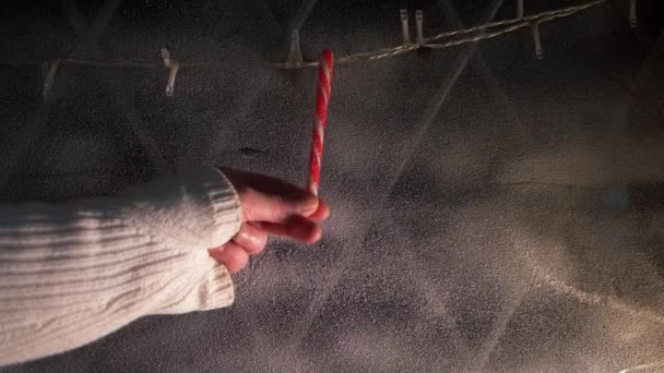 Kädet roikkuu Candy Cane koristeet joulun ikkunassa - Materiaali, video