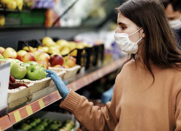 close up. woman in protective gloves choosing fruit in the store. - Fotó, kép