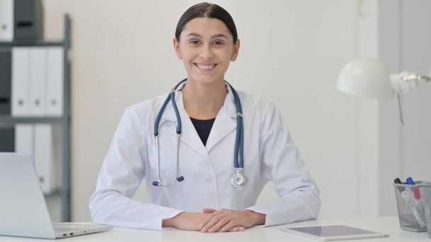 Жінка лікар посміхається в клініці в камері
  - Фото, зображення