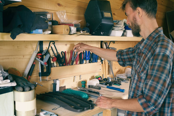 Joiner woodworker choosing construction carpentry tools in his workshop. DIY concept. - Fotoğraf, Görsel