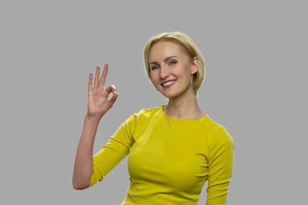 Красивая женщина показывает хорошо знак с пальцами. - Фото, изображение