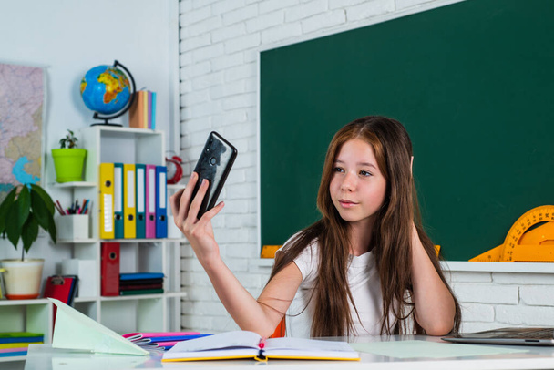 making selfie. girl is college student. back to school. teen girl work in classroom with smartphone. cheerful kid learning subject online. modern education. knowledge day. child pupil with phone - Foto, immagini