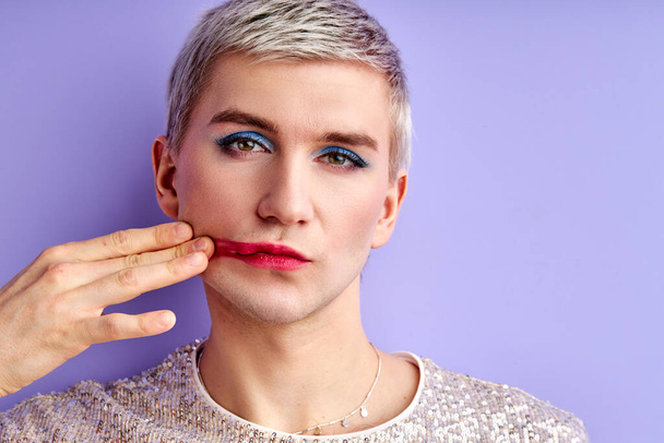 transgender man smears lipstick on his cheek - Foto, Imagen