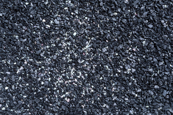 Μαύρη υφή άμμου. Πλήρης εικόνα καρέ της σκουρόχρωμης επιφάνειας της άμμου. Αφηρημένο φόντο μοτίβο. Στοιχείο κοντινού σχεδιασμού. Άνω όψη. - Φωτογραφία, εικόνα