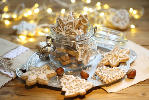 Glazed gingerbread cookies on the background of a burning garland - Photo, Image