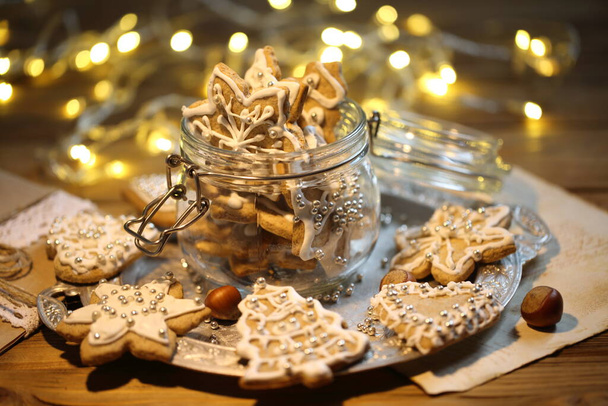 Glazed gingerbread cookies on the background of a burning garland - Zdjęcie, obraz