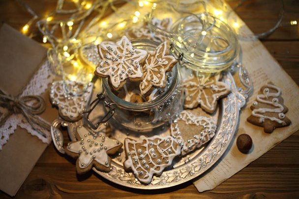 Glazed gingerbread cookies on the background of a burning garland - Foto, immagini