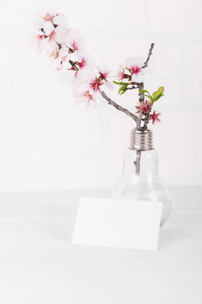 アーモンドの木の枝が咲く白い空のカードモックアップ。あなたの愛のためのバレンタインデーカード - 写真・画像