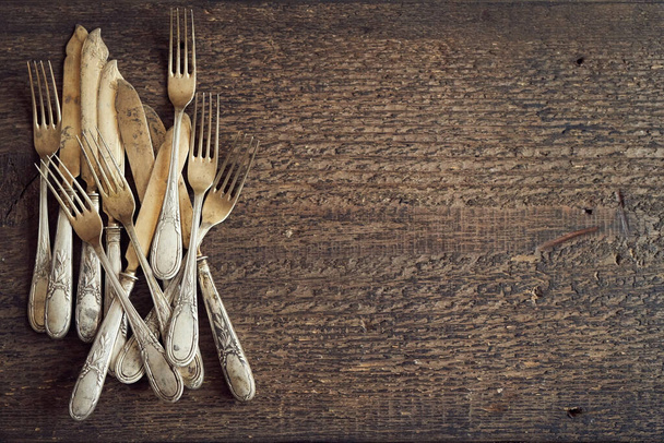 Old rusted vintage silverware on a wooden background, top view with copy space - Photo, Image