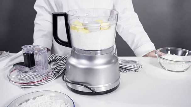 Mixing ingredients in a food processor to prepare homemade coconut cookies. - Photo, Image