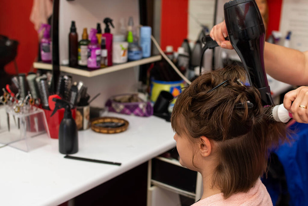 Kaunis teini tyttö kampaaja isku kuivaus hänen hiukset leikkaamisen jälkeen - Valokuva, kuva