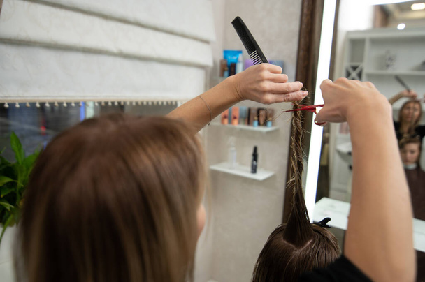 Widok przyciętych włosów fryzjerskich nożyczkami w salonie fryzjerskim - Zdjęcie, obraz
