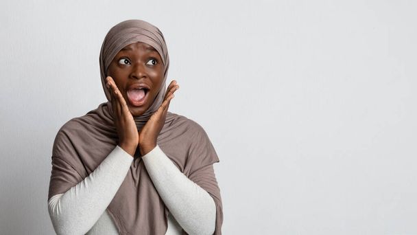 Gran oferta. Sorprendido Negro musulmana dama mirando espacio de copia con emoción - Foto, Imagen