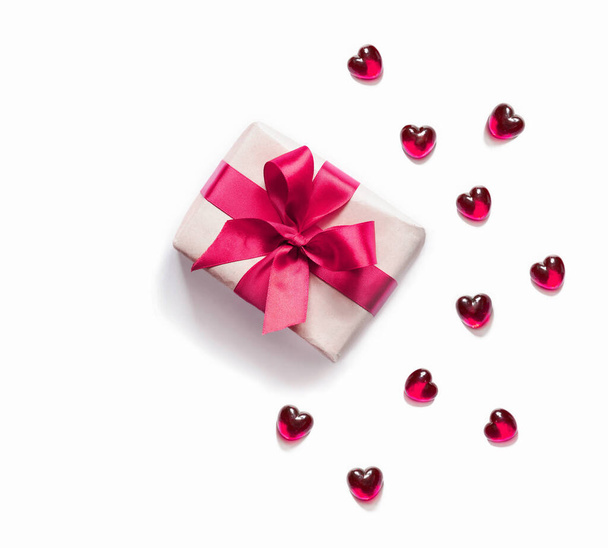 Caja de regalo con cinta roja y corazones sobre fondo blanco. Concepto de vacaciones. - Foto, imagen